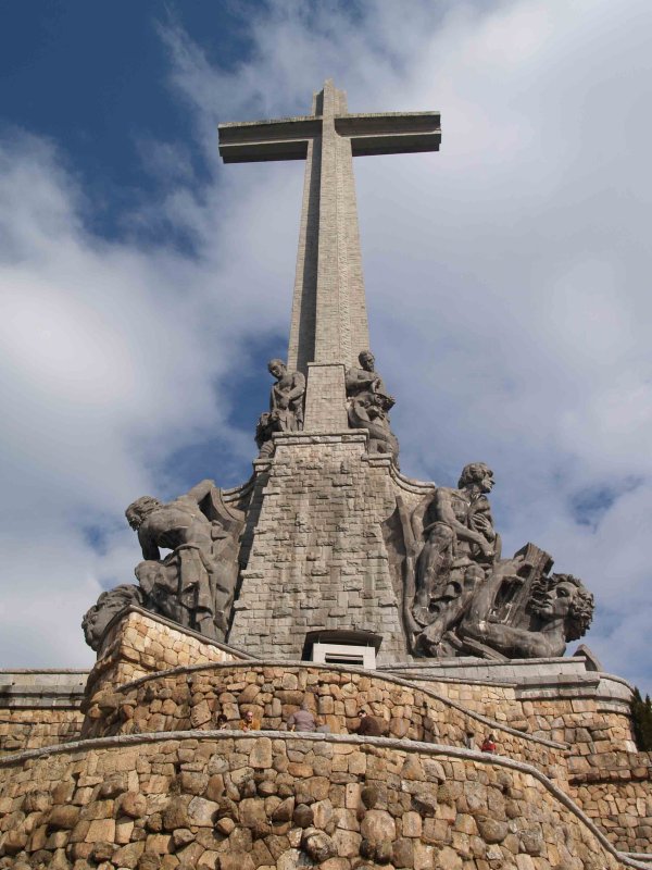 CRUZ VISTA DE LA PARTE DEL MONASTERIO DE 150 METROS DE ALTURA. DE IZQUIERDA A DERECHA: LA VIRTUD DE LA TEMPLANZA  Y DE LA FORTALEZA. EL EVANGELISTA SAN ARCOS SOBRE EL LE&Oacute;N Y EL EVANGELISTA AL QUE EL &Aacute;NGEL LE EST&Aacute; PONIENDO EL LIBRO PARA ESCRIBIR EL EVANGELIO